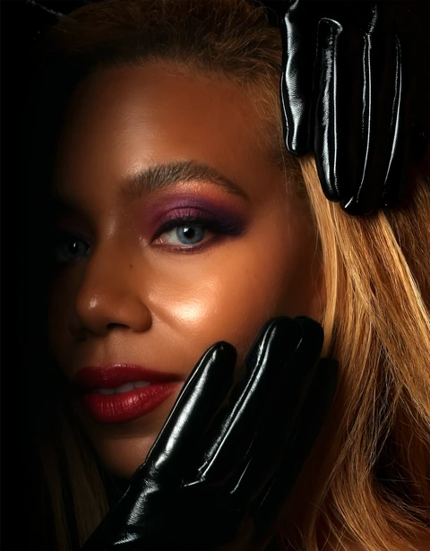 Daisi Jo beauty close-up with dramatic purple eye makeup, red lipstick and black gloves