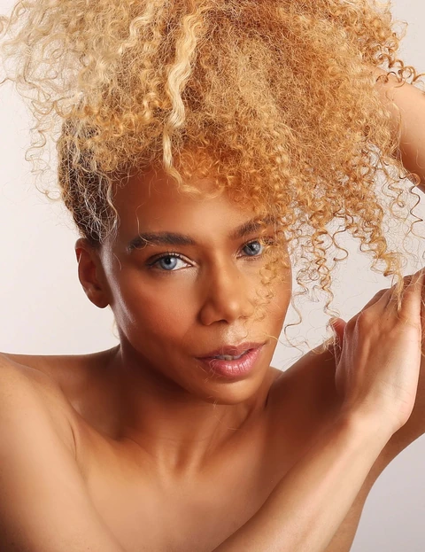 Daisi Jo — portrait with blonde curls swept upward