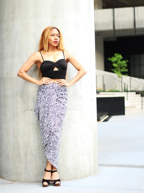 Daisi Jo modeling a black crop top and animal-print skirt with hands on hips