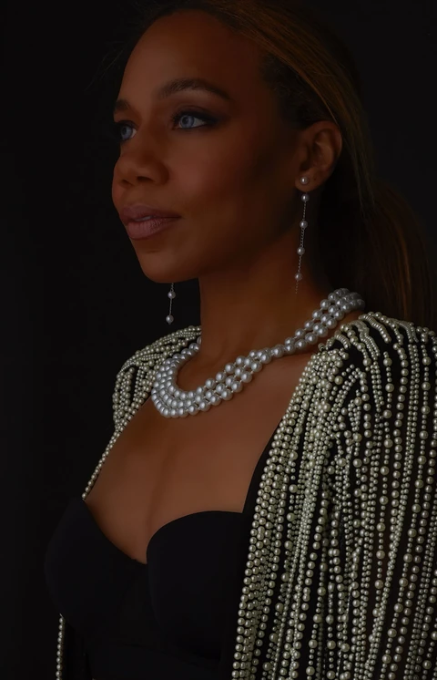 Daisi Jo wearing a pearl-embellished jacket, layered pearl necklaces and drop earrings