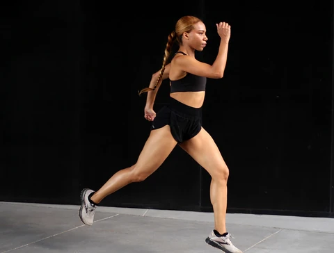 Daisi Jo running in black activewear against a dark background